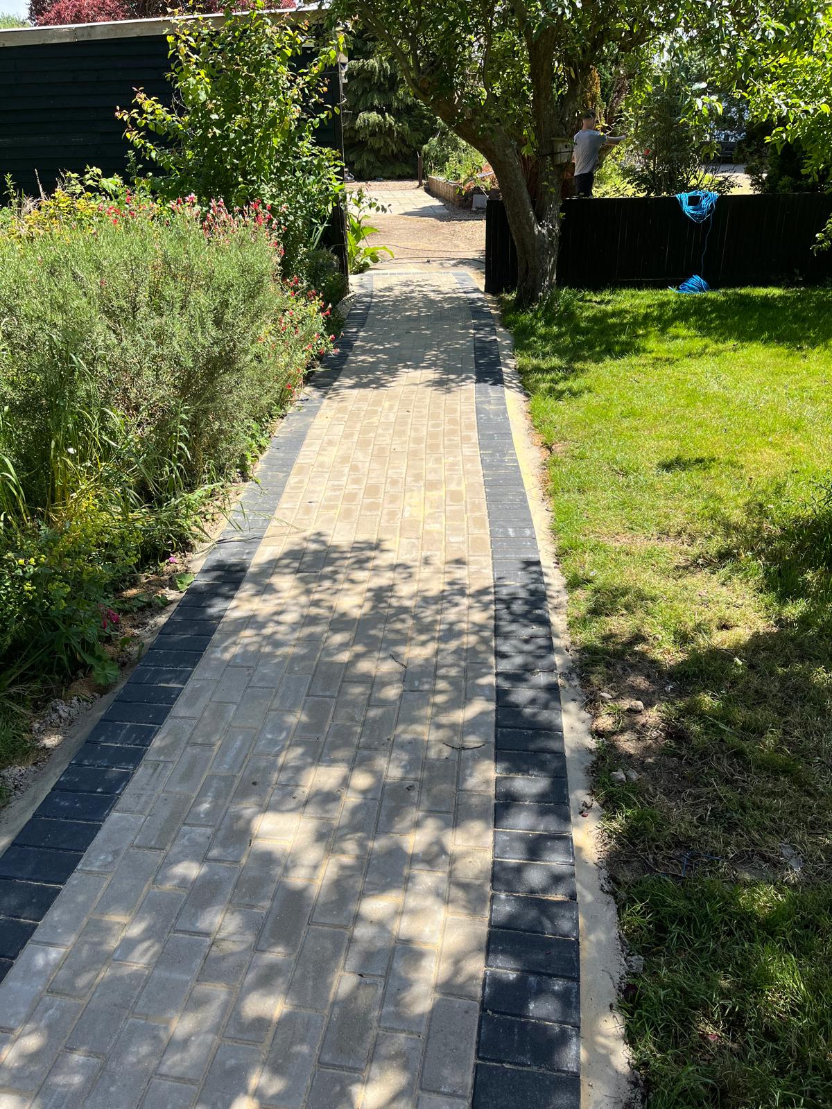 Curved light stone garden path with dark edging