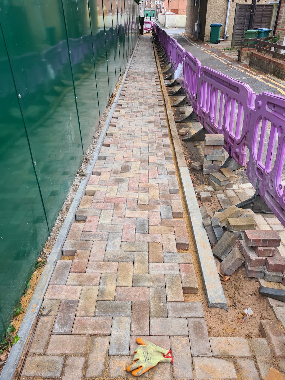 Part-laid block-paved route beside barriers