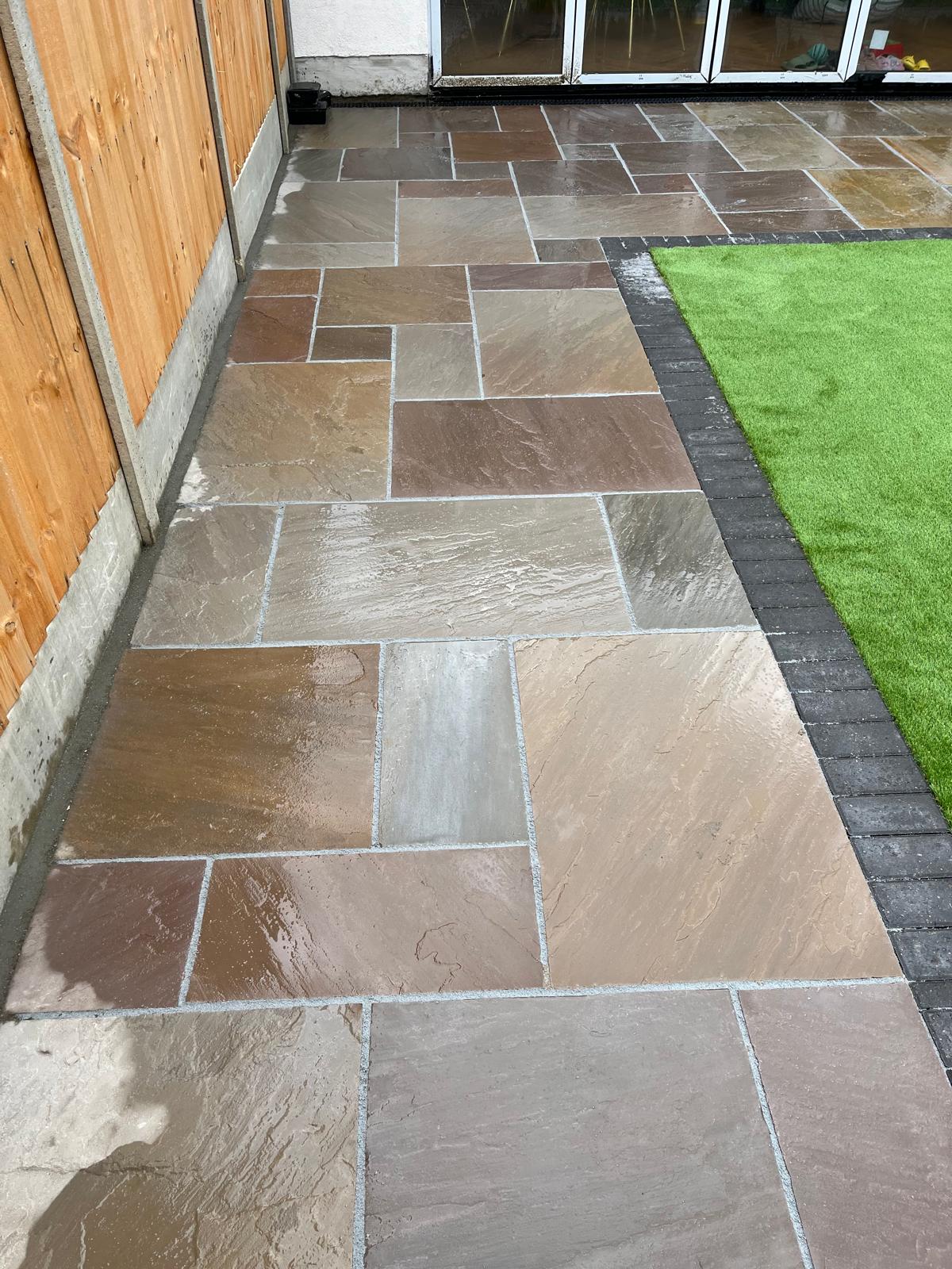 Natural stone paving beside artificial lawn